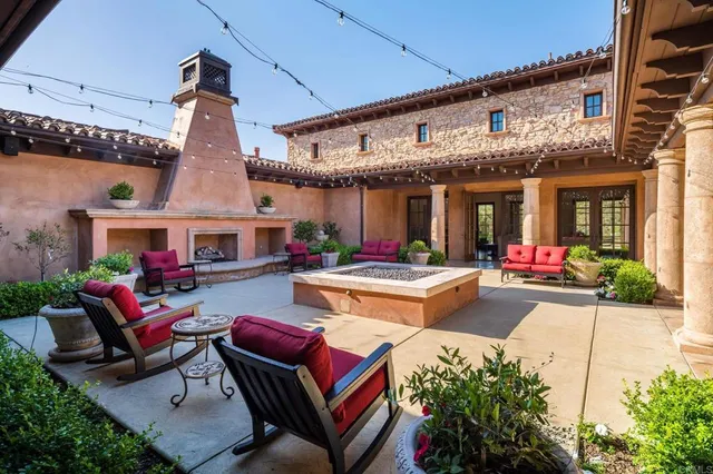 a view of a patio with couches table and chairs with potted plants
