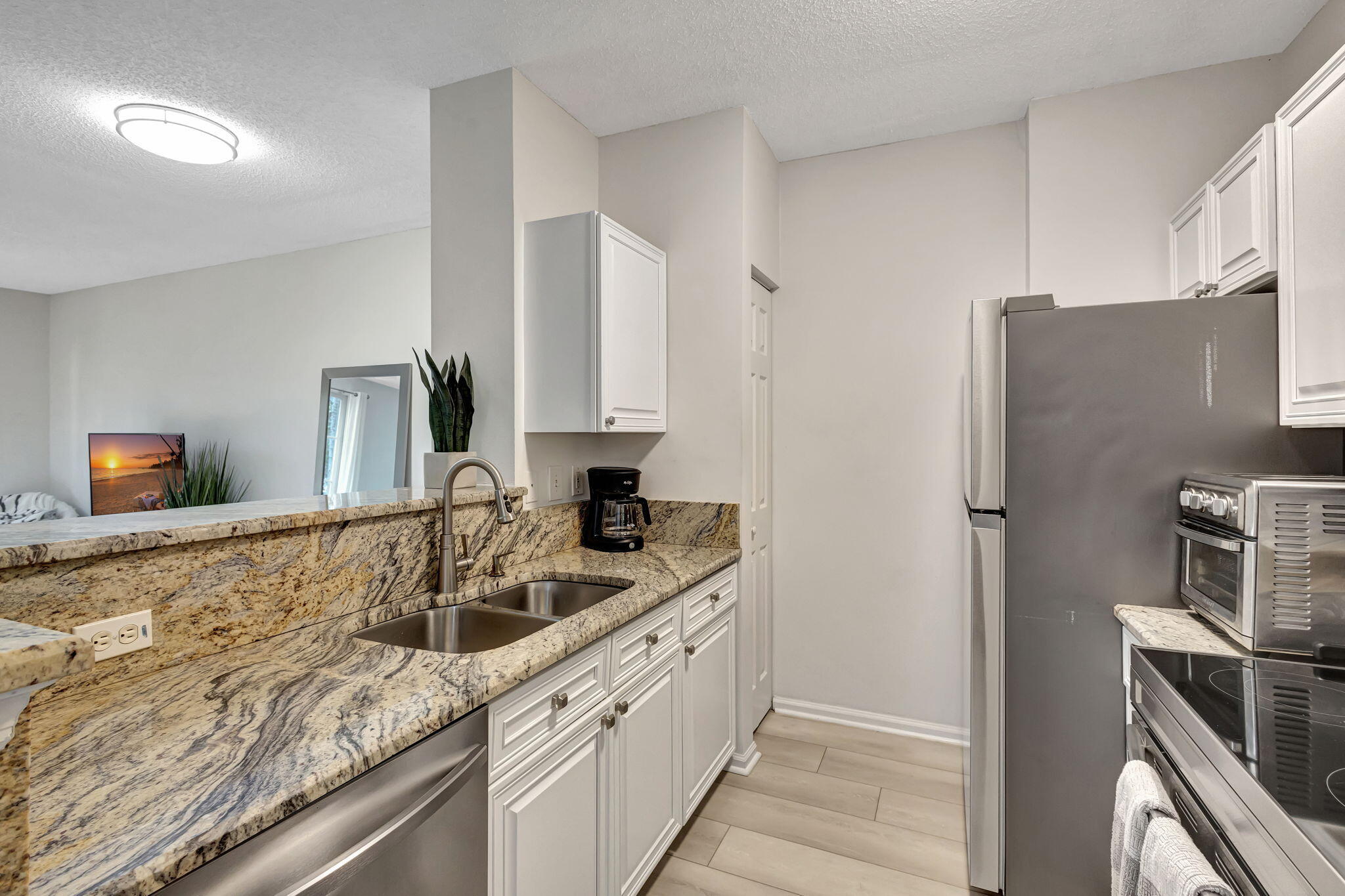 630 South Sapodilla Avenue, Unit 223 West Palm Beach, FL 33401 - Photo 13 of 43 a kitchen with stainless steel appliances granite countertop a sink stove and refrigerator