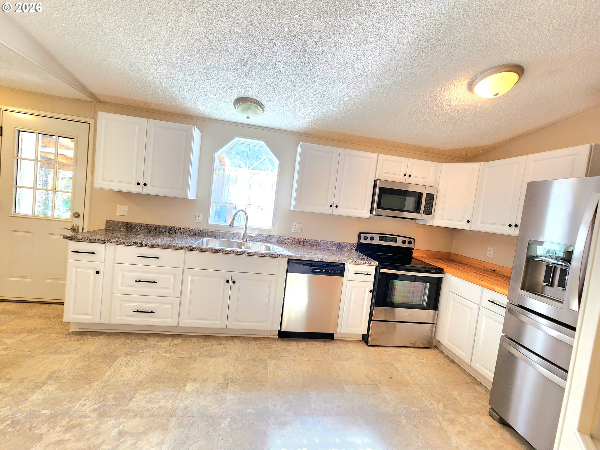 874 South Main Street Canyonville, OR 97417 - Photo 9 of 30 a kitchen with granite countertop white cabinets and stainless steel appliances