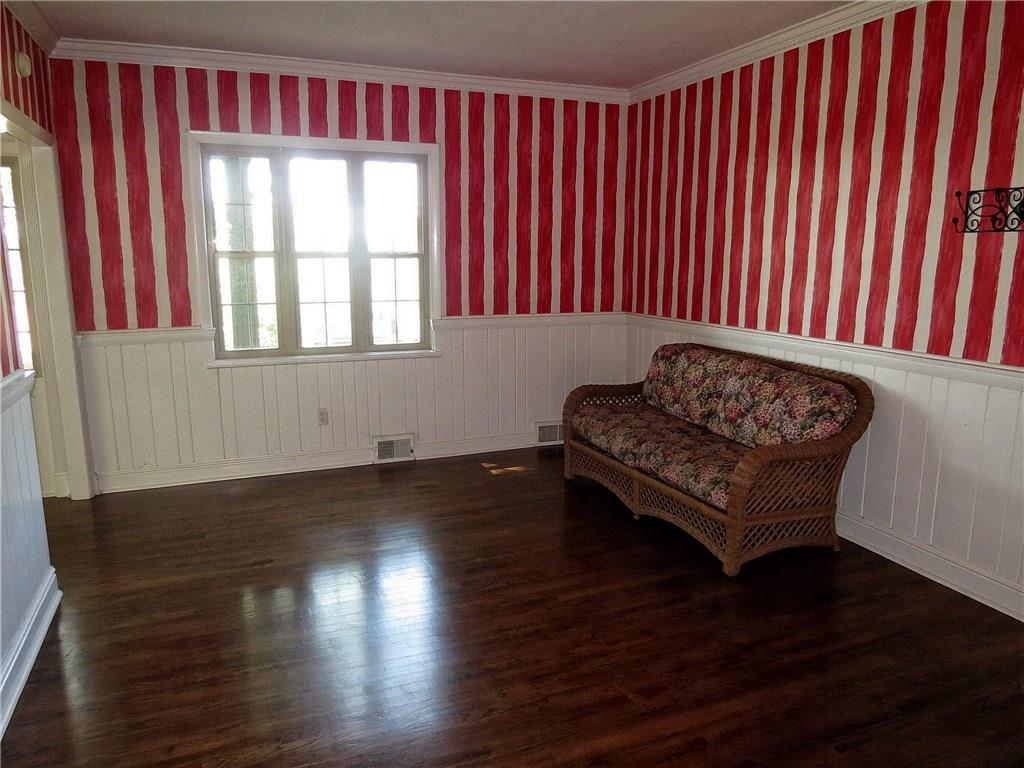 A traditional 15X13 dining room includes hardwood floors, crown molding and cottage style wood paneled walls.