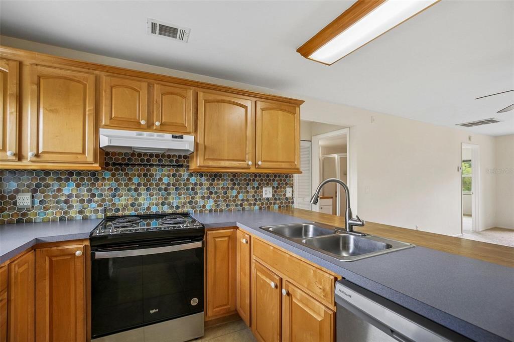 26485 Rampart Boulevard, Unit A27 Punta Gorda, FL 33983 - Photo 12 of 27 a kitchen with stainless steel appliances granite countertop a sink stove and cabinets