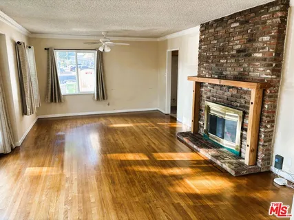 a view of an empty room with glass door and wooden floor