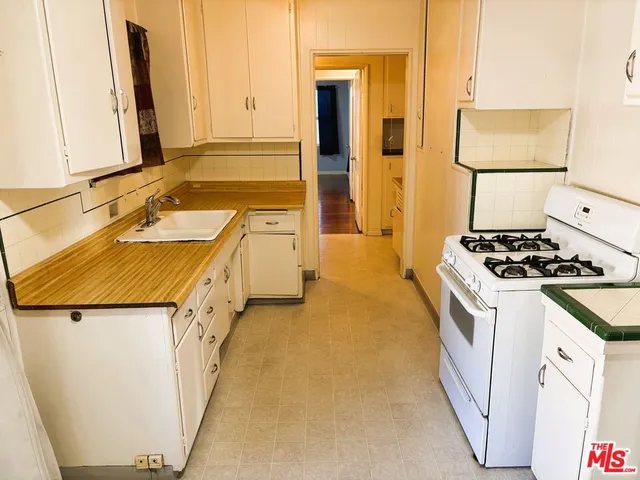 a kitchen with a sink stove and cabinets