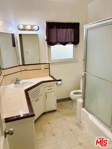 a bathroom with a sink a toilet and mirror