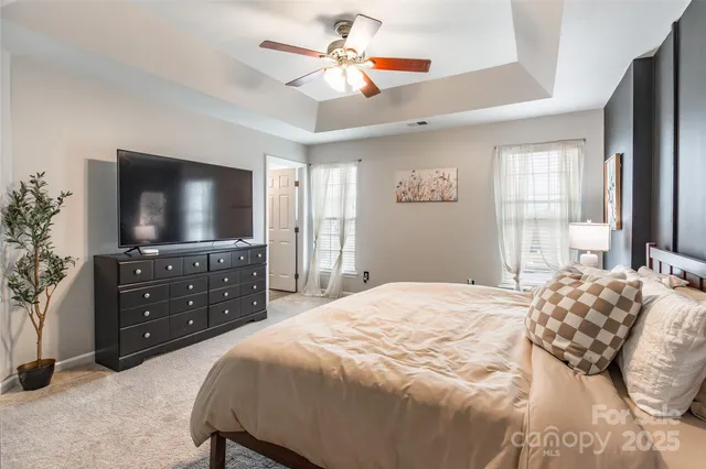 a bedroom with a bed and a flat screen tv on dresser
