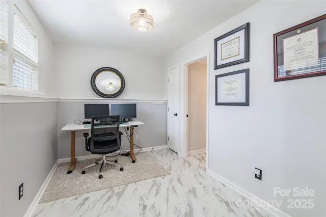a view of a workspace with furniture and a window
