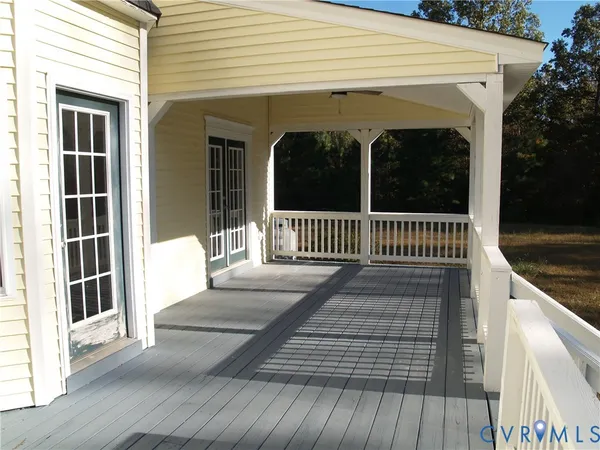 a view of a balcony with wooden floor and floor to ceiling window