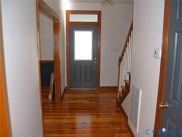 a view of a hallway with wooden floor and staircase