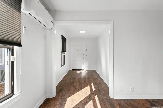 a view of a hallway to a bedroom with wooden floor
