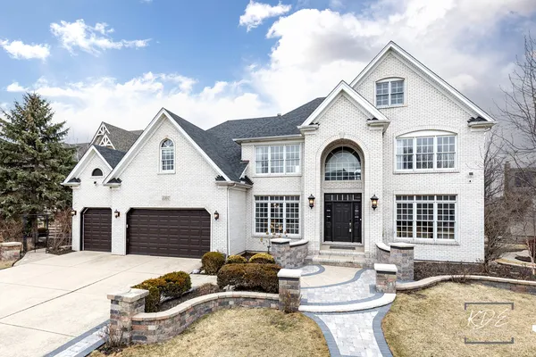 a view of a white house with large windows and couches