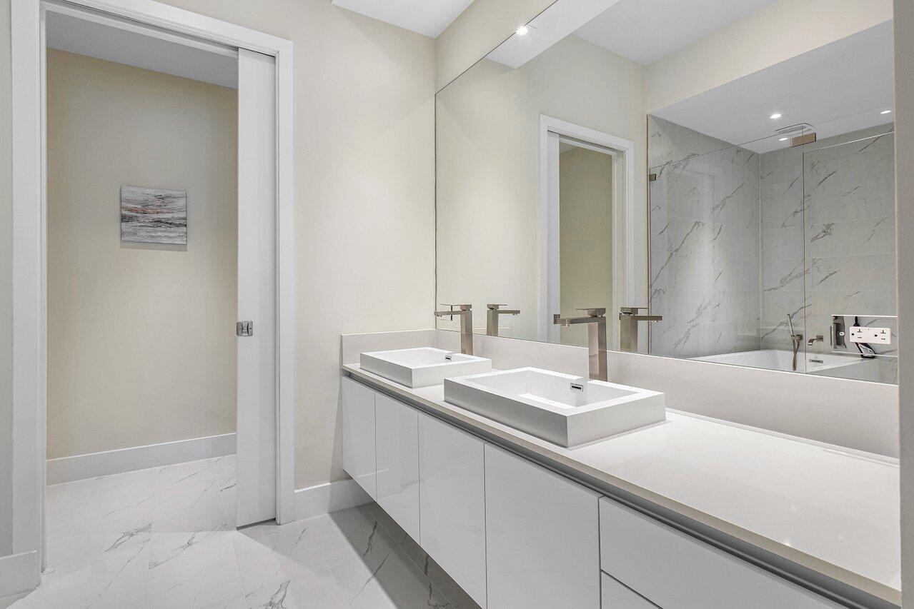 3100 North Ocean Drive, Unit H1205 Singer Island, FL 33404 - Photo 15 of 35 a bathroom with 2 sink tub and a mirror