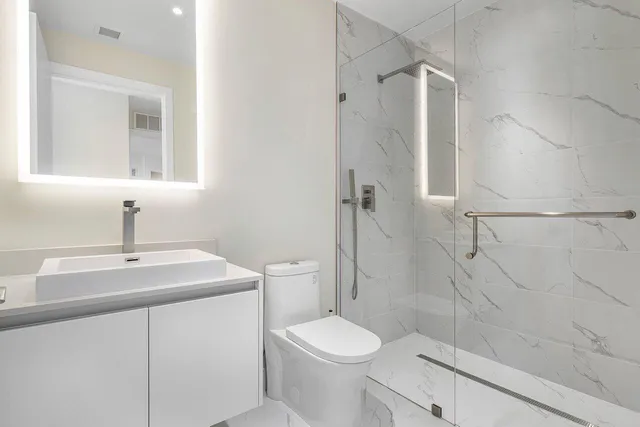 a bathroom with a sink a toilet and shower