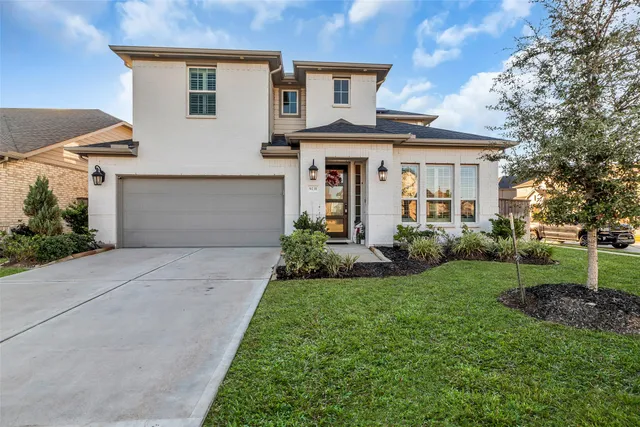 a front view of a house with a yard and trees