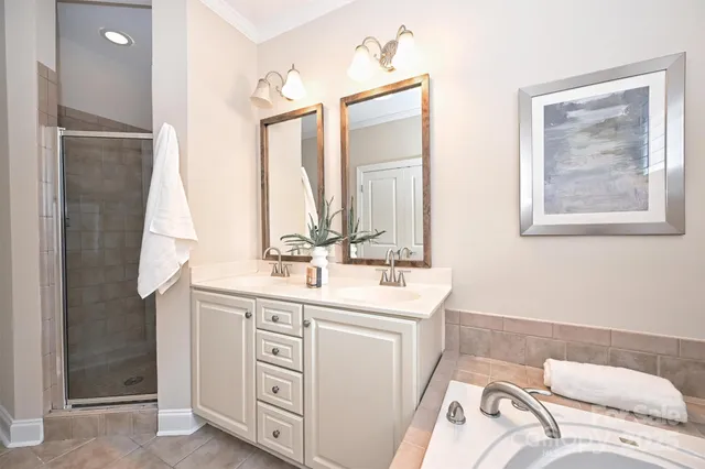 a en suite bathroom with a double vanity sink and a mirror