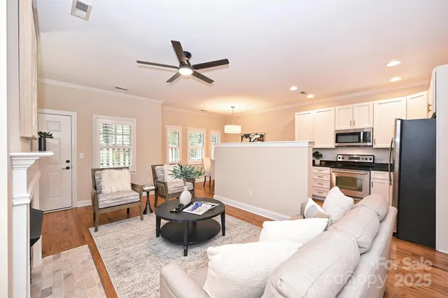 a living room with furniture and a view of kitchen