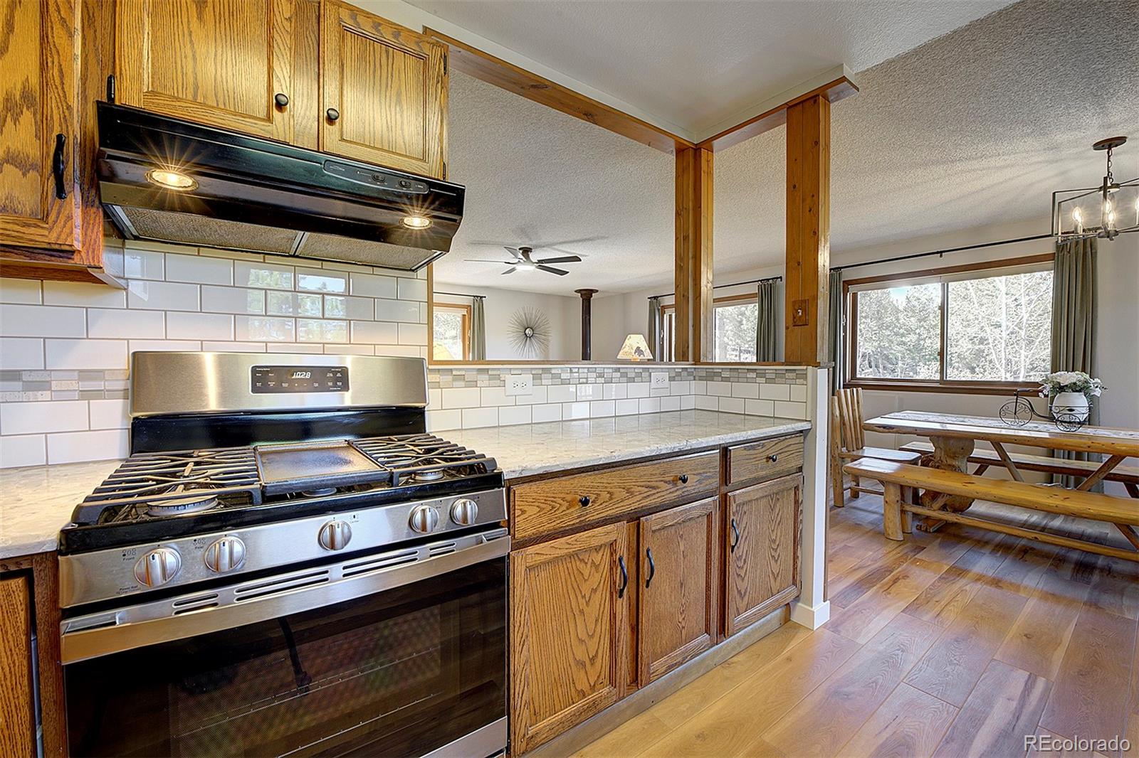 81 Fir Lane Bailey, CO 80421 - Photo 12 of 33 a kitchen with granite countertop wooden cabinets and a stove top oven