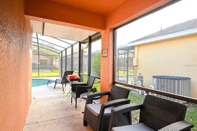 a living room with furniture and floor to ceiling windows