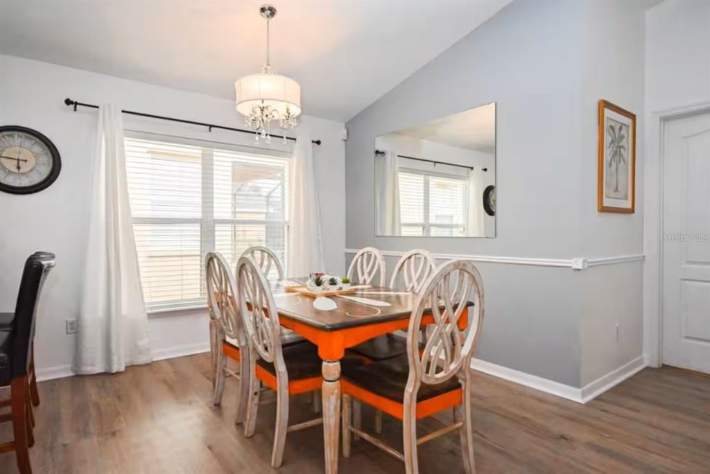 1904 Royal Ridge Drive Davenport, FL 33896 - Photo 4 of 15 a dining room with furniture a chandelier and wooden floor