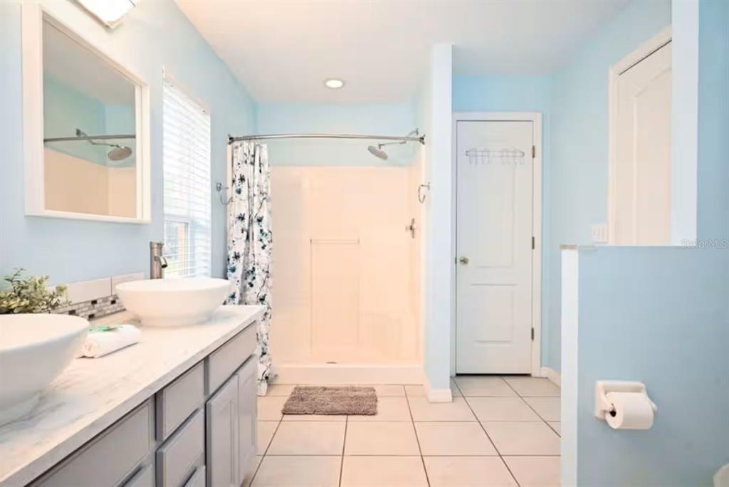 1904 Royal Ridge Drive Davenport, FL 33896 - Photo 7 of 15 a bathroom with a shower sink and mirror
