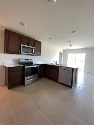 a large kitchen with stainless steel appliances granite countertop a stove and a sink