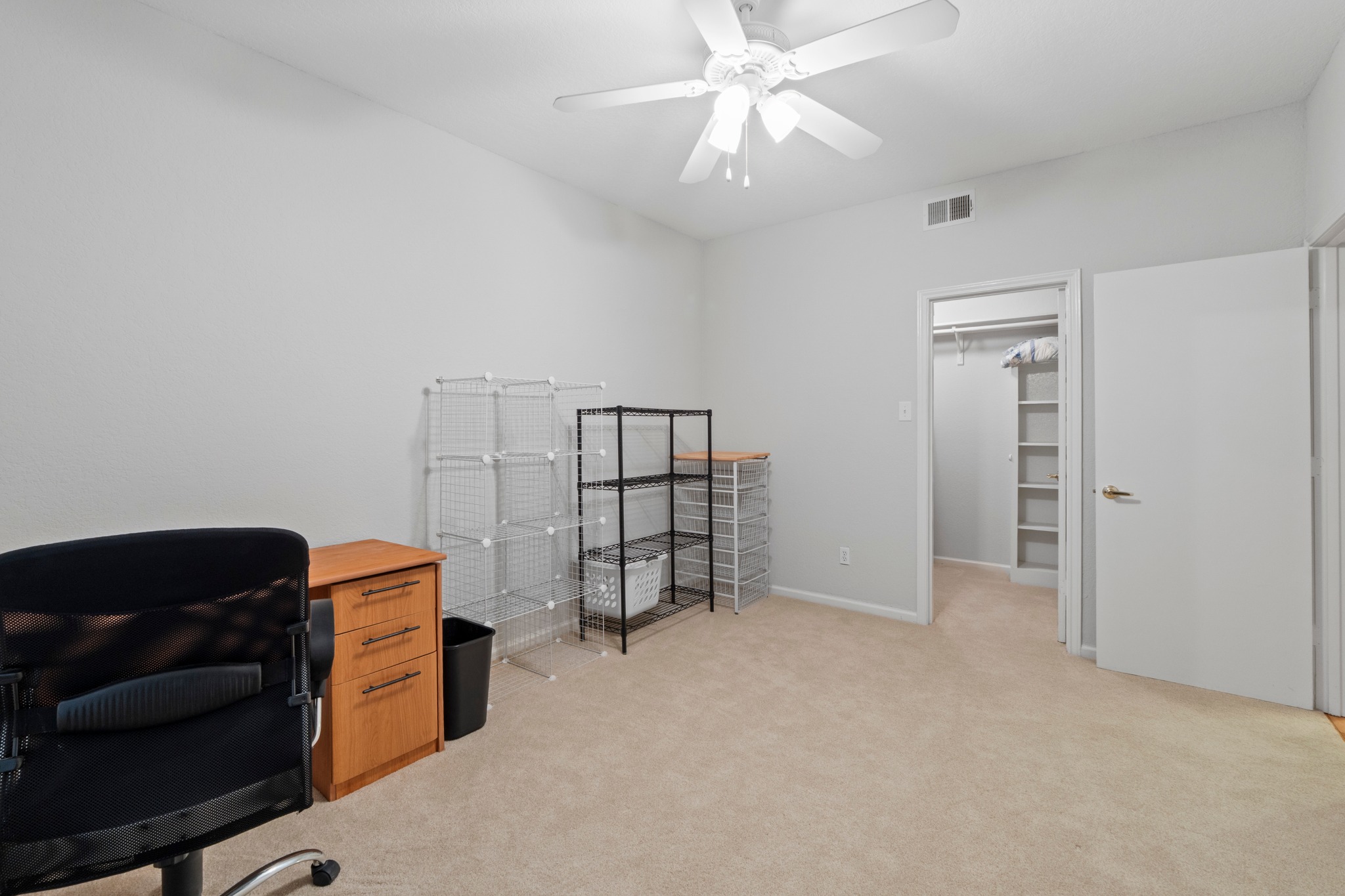 4711 Spicewood Springs Road, Unit 8146 Austin, TX 78759 - Photo 14 of 17 Room featuring neutral carpeting, light gray walls, a white ceiling fan, and a walk-in closet with built-in shelving