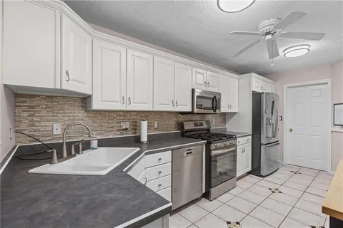 a kitchen with stainless steel appliances granite countertop a stove sink and cabinets