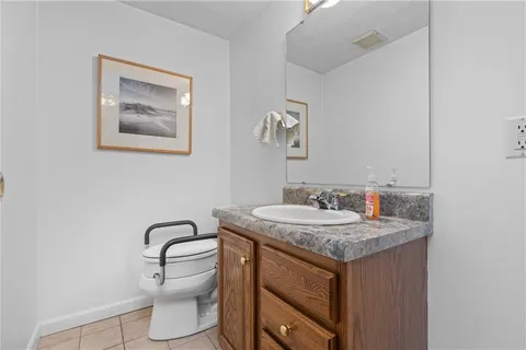 a bathroom with a granite countertop sink a toilet and mirror