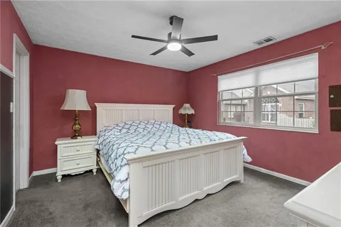 a bedroom with a bed chandelier and a window