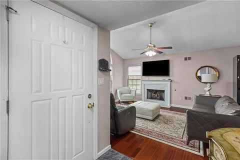 a living room with furniture a fireplace and a flat screen tv
