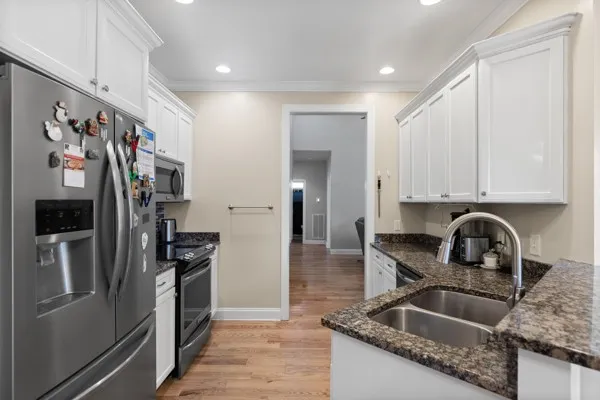 a kitchen with stainless steel appliances granite countertop a sink stove and refrigerator