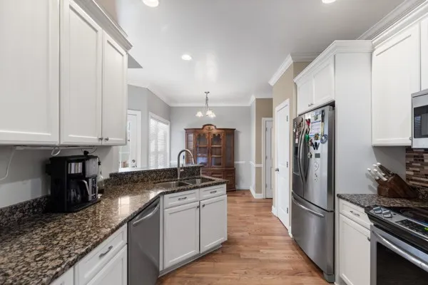 a kitchen with stainless steel appliances granite countertop a sink stove and refrigerator