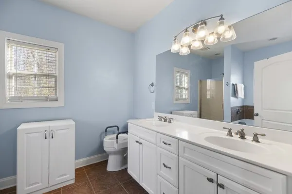 a bathroom with a double vanity sink mirror and toilet
