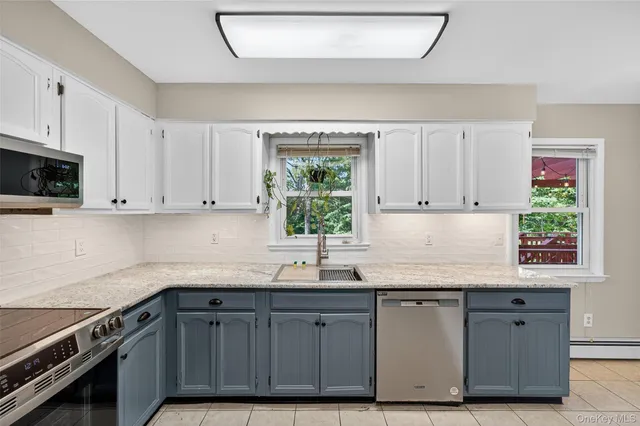 a kitchen with granite countertop a sink window and cabinets