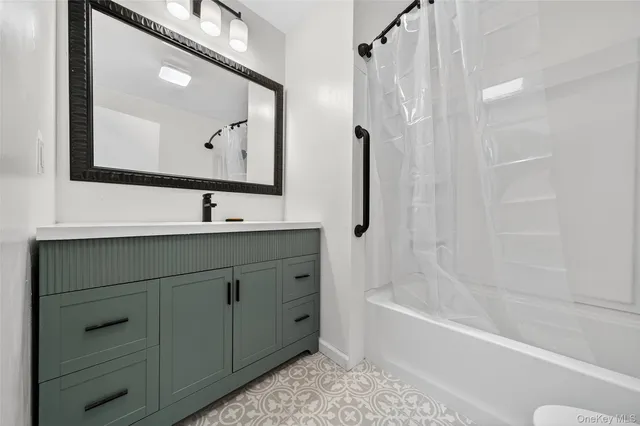 a bathroom with a bathtub sink vanity and mirror