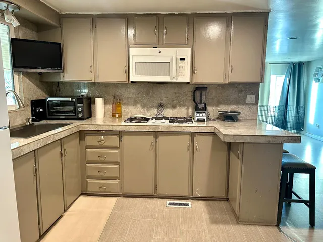 a kitchen with stainless steel appliances granite countertop a stove a sink and a microwave