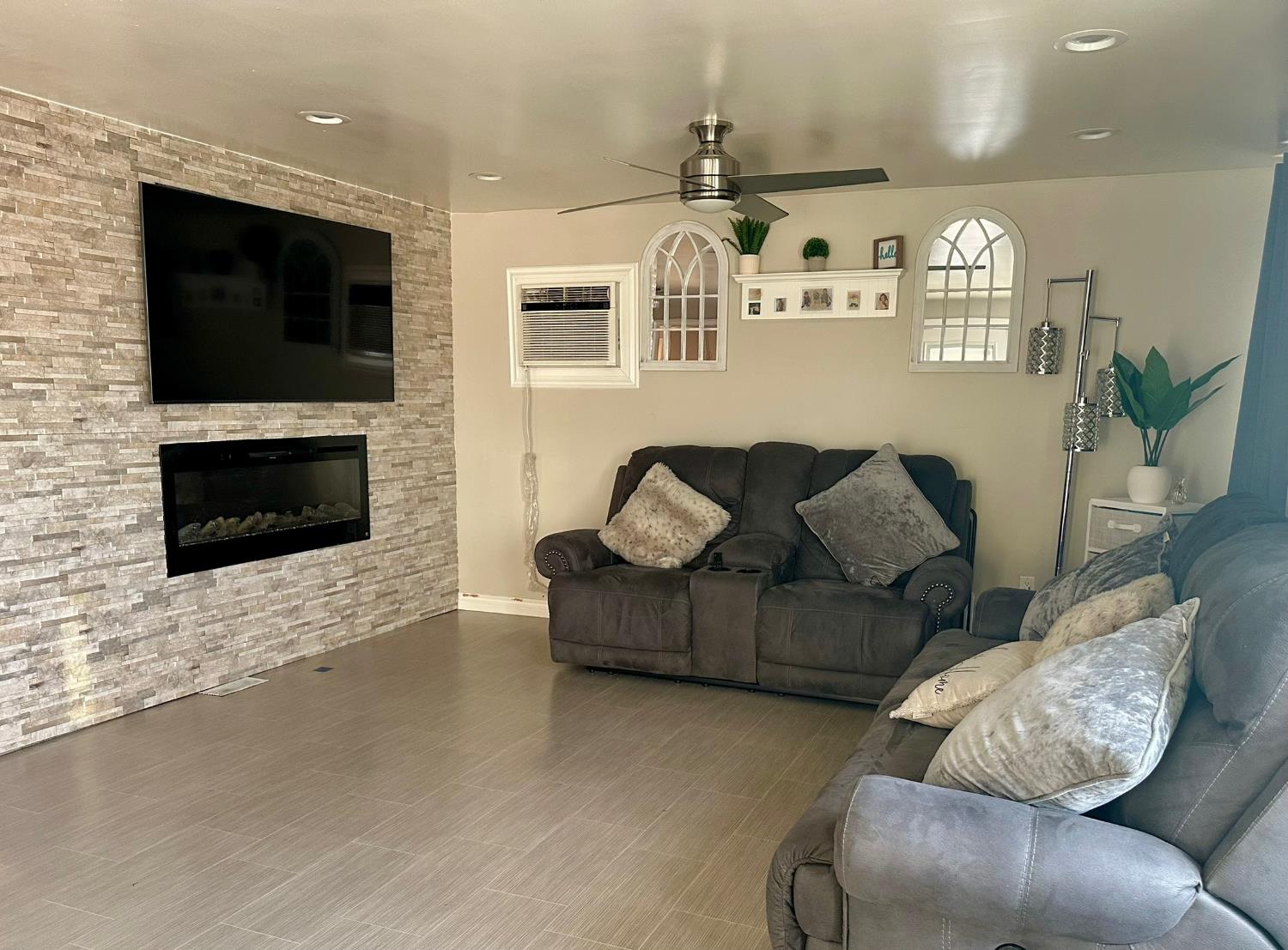 3435 Marfargoa Road, Unit 74 Stockton, CA 95215 - Photo 7 of 21 a living room with furniture a flat screen tv and a fireplace