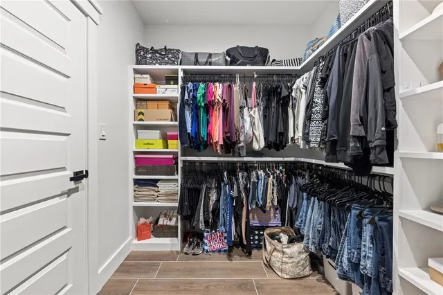 a view of walk in closet with clothes and shoes