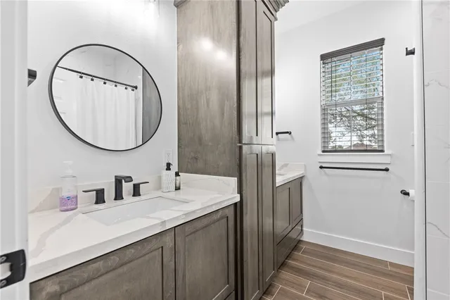 a bathroom with a sink a mirror a vanity and a shower