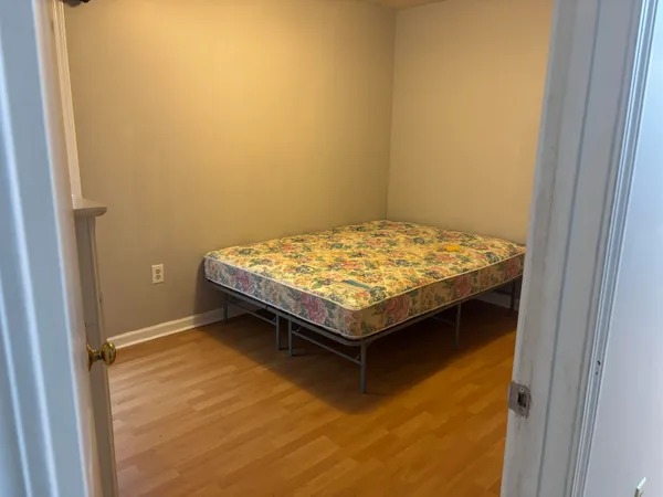 a bedroom with a bed and wooden floor