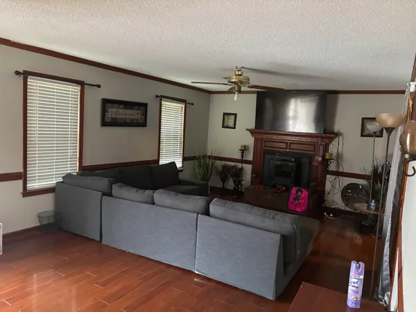 a living room with furniture a flat screen tv and a window