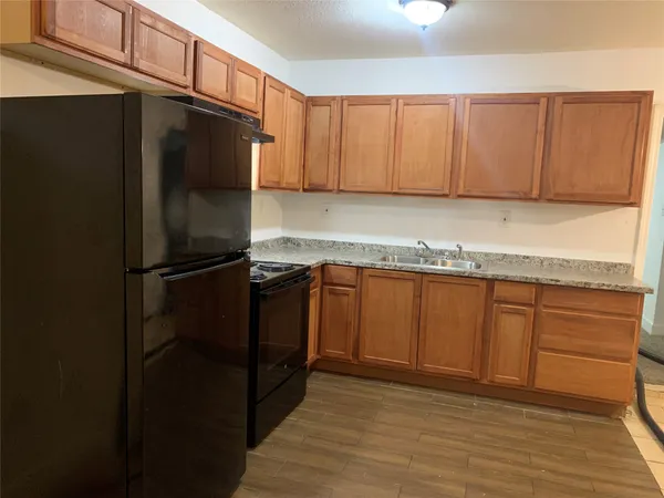 a kitchen with granite countertop wooden cabinets and a stainless steel appliances