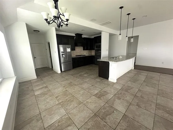 a view of a kitchen with stainless steel appliances granite countertop a sink and a refrigerator