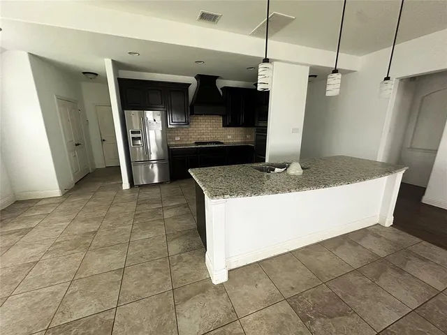 a kitchen with stainless steel appliances granite countertop a refrigerator and a stove