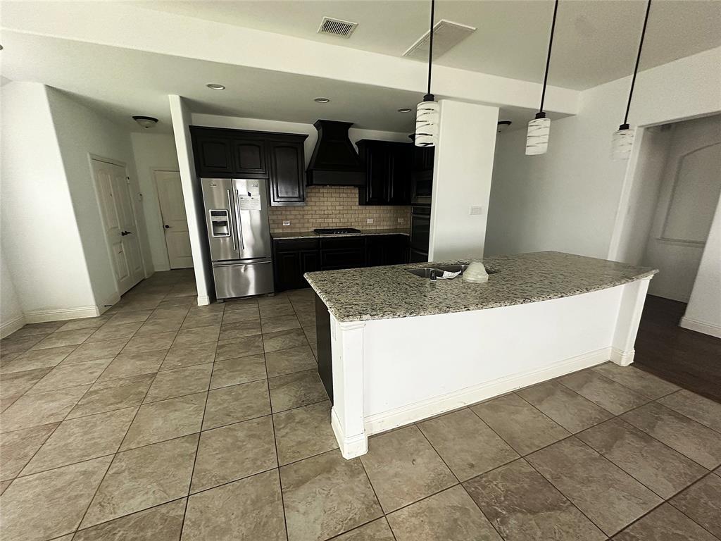 2403 Wilson Drive Anna, TX 75409 - Photo 8 of 13 a kitchen with stainless steel appliances granite countertop a refrigerator and a stove