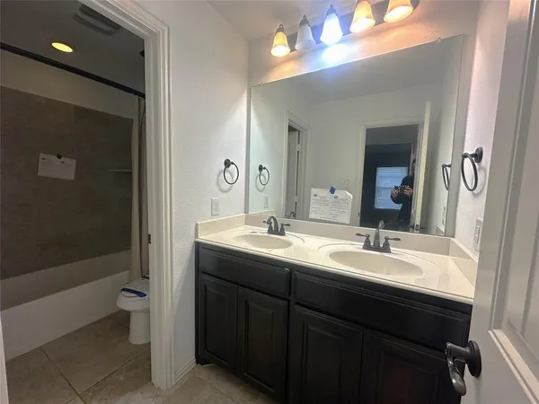 a bathroom with a double vanity sink toilet and shower