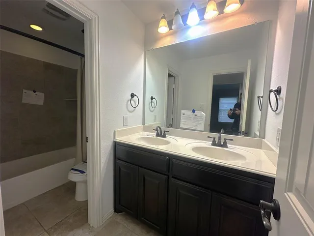 a bathroom with a double vanity sink toilet and shower