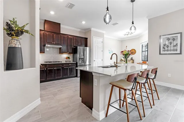 a kitchen with a refrigerator and a stove top oven