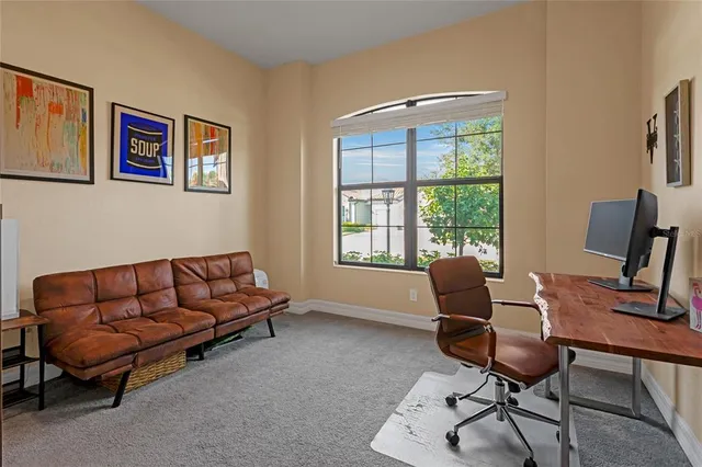 a living room with patio furniture and a floor to ceiling window