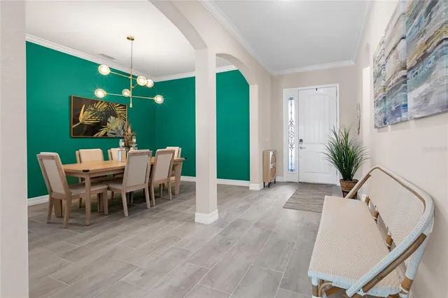 a living room with furniture a flat screen tv and a dining table