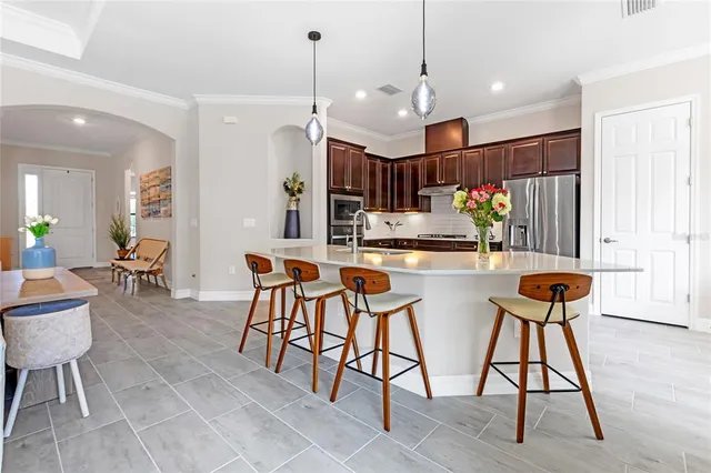 a kitchen with stainless steel appliances kitchen island granite countertop a table and chairs in it